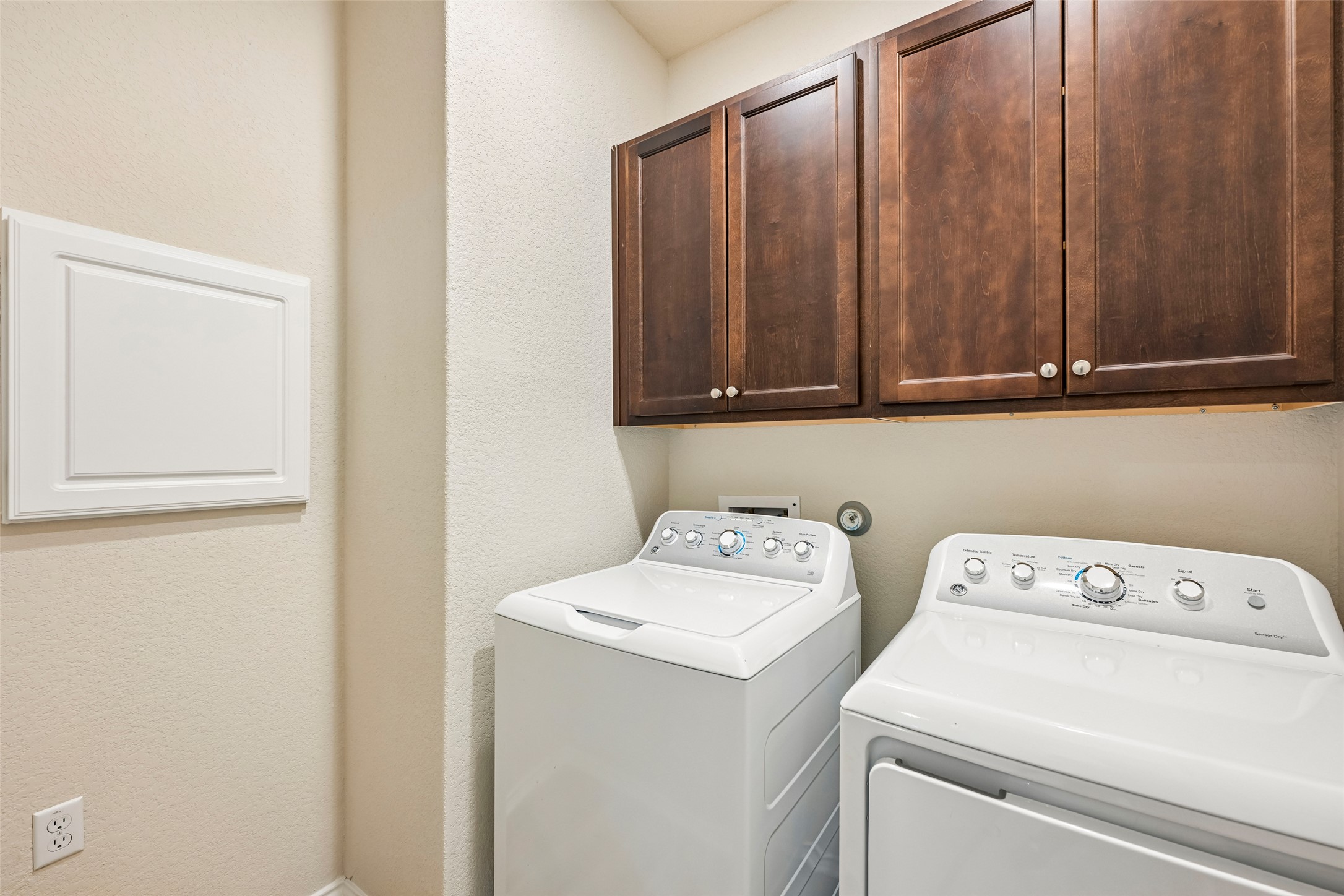 401 Yorktown Street Georgetown, TX 78633 - Photo 30 of 38 Dedicated laundry area featuring dark wood-finish cabinetry with white knob hardware and a white laundry chute
