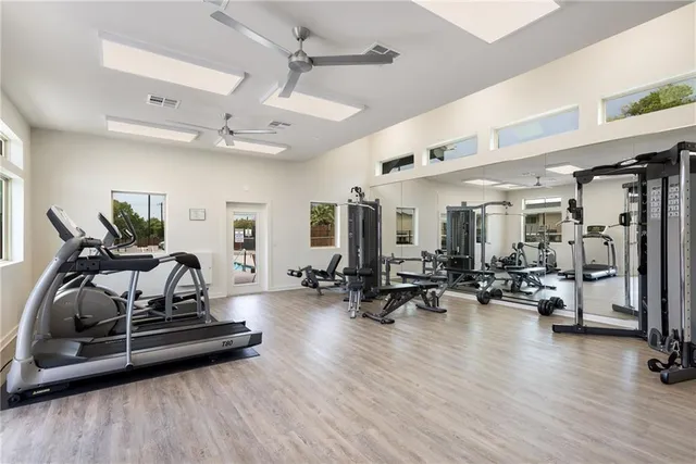 a living room with furniture gym equipment and a wooden floor