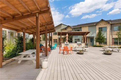 a view of a patio with lawn chairs floor to ceiling window next to a yard