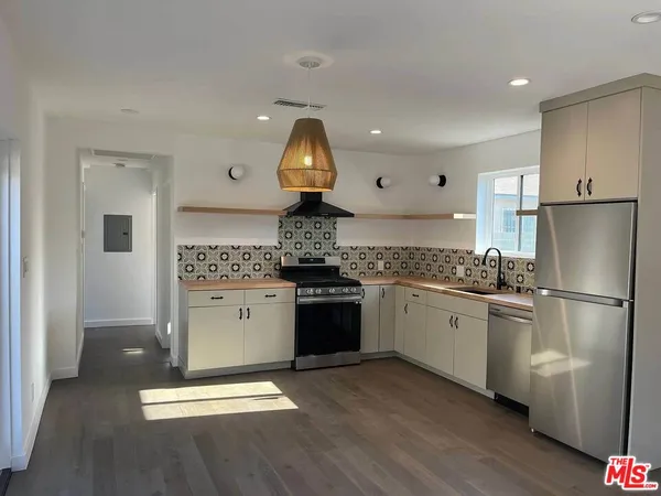 a kitchen with a refrigerator sink and cabinets
