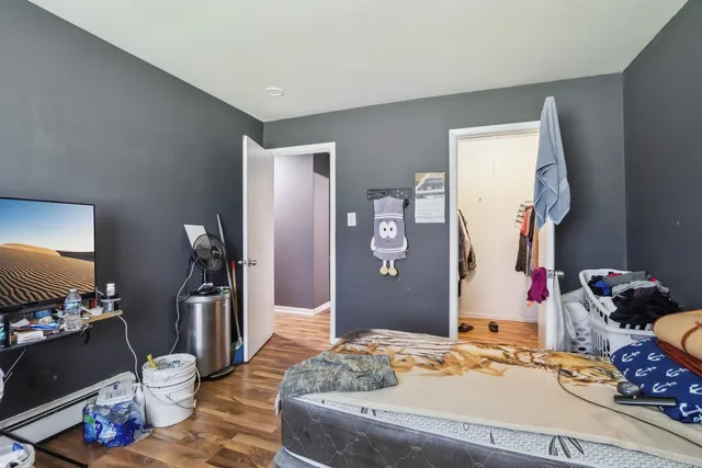 a bedroom with a bed and wooden floor