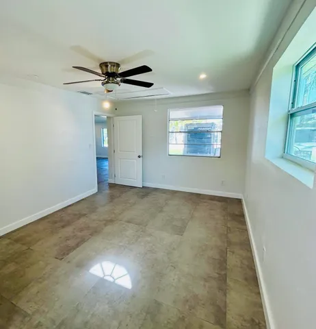 an empty room with windows and fan view