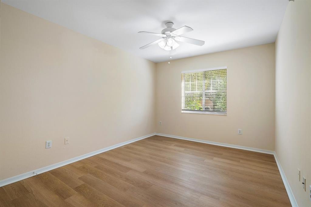 6492 Emerald Dunes Drive, Unit 208 West Palm Beach, FL 33411 - Photo 11 of 37 an empty room with windows and chandelier fan