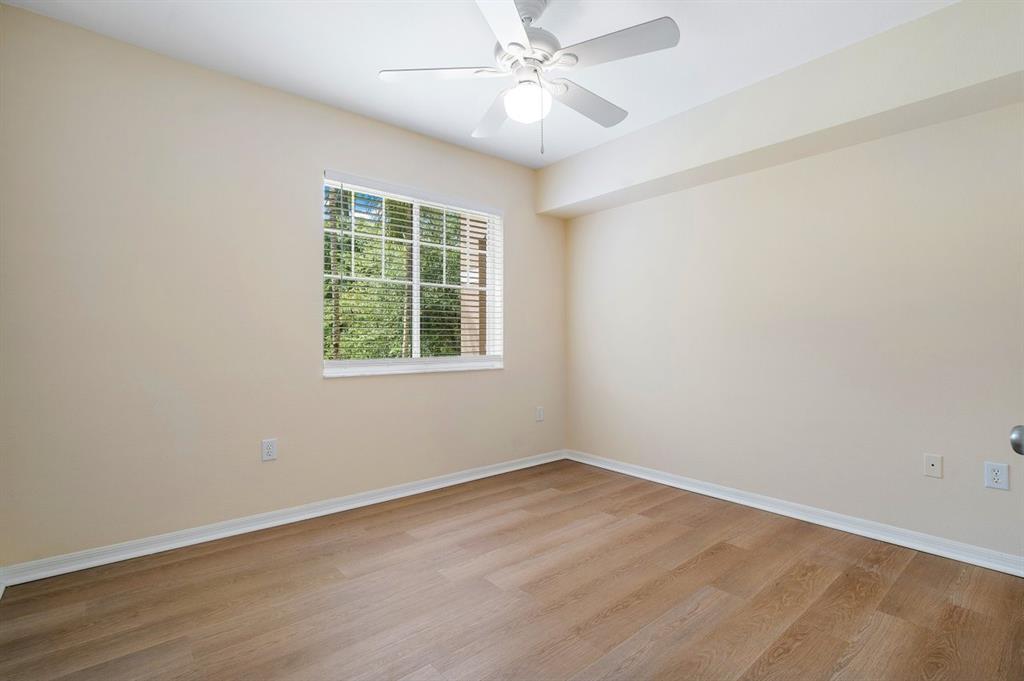 6492 Emerald Dunes Drive, Unit 208 West Palm Beach, FL 33411 - Photo 14 of 37 wooden floor in an empty room with a window