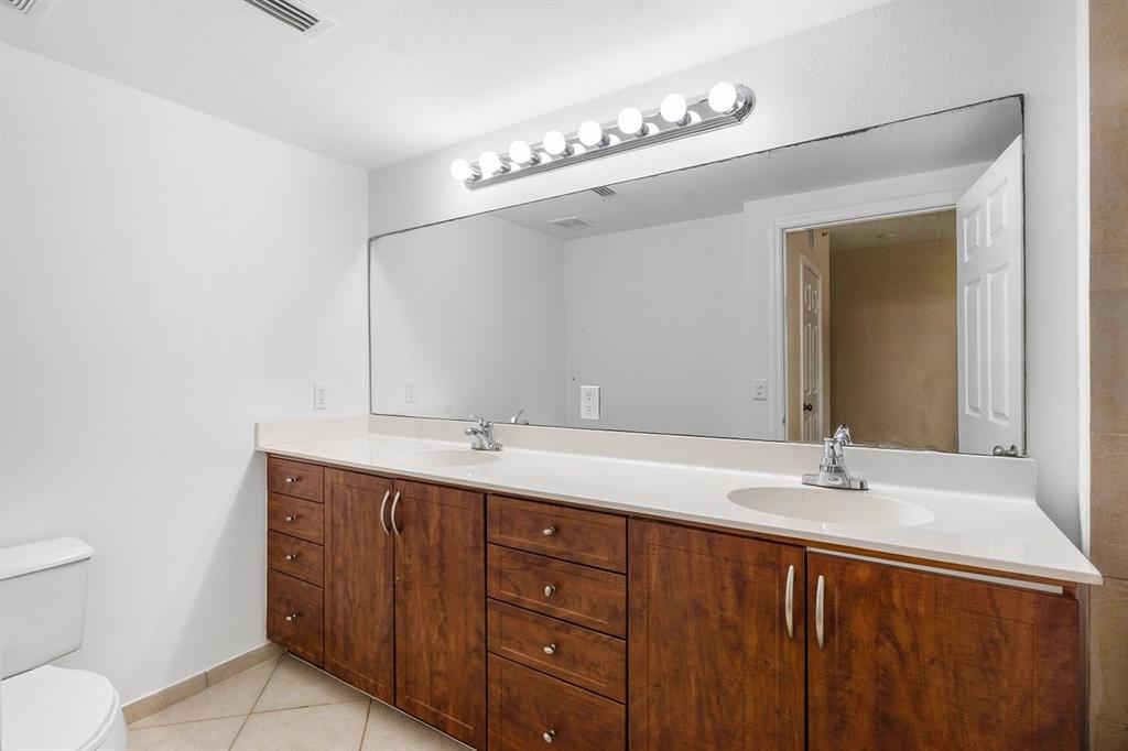 6492 Emerald Dunes Drive, Unit 208 West Palm Beach, FL 33411 - Photo 20 of 37 a bathroom with a granite countertop sink a toilet and a mirror
