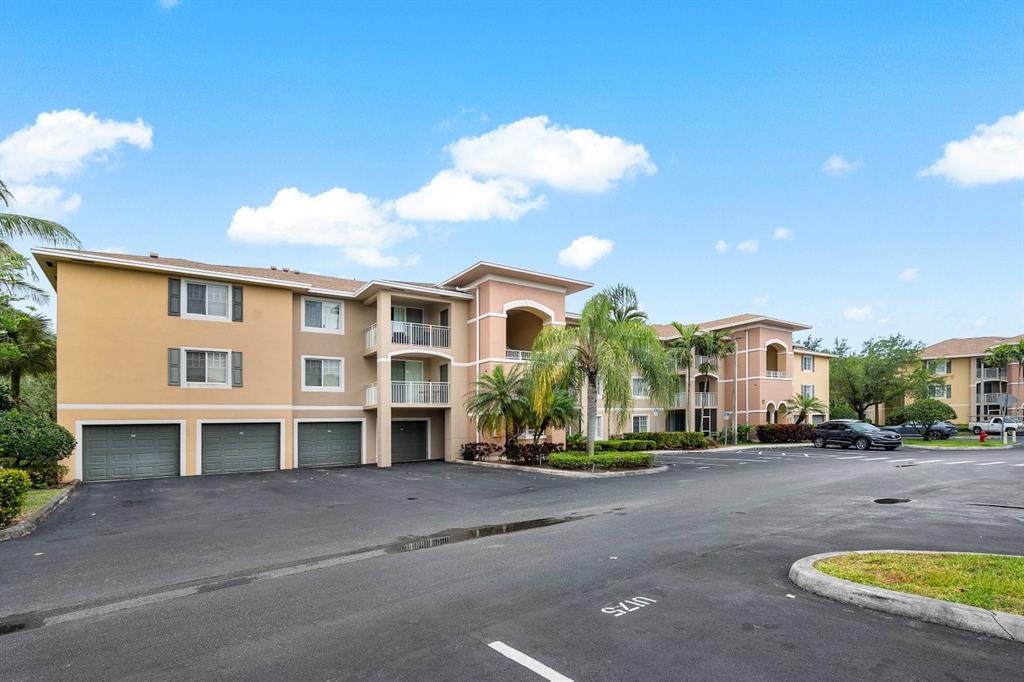 6492 Emerald Dunes Drive, Unit 208 West Palm Beach, FL 33411 - Photo 3 of 37 a front view of a house with a yard