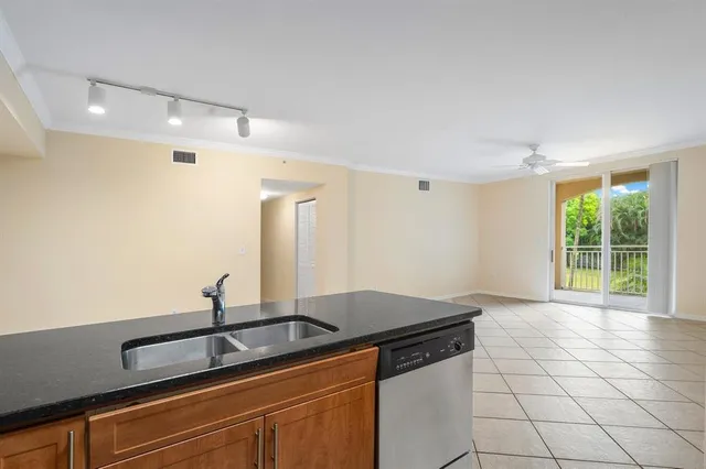 an empty room with windows and chandelier fan