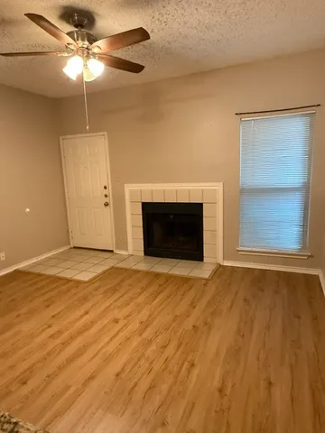 a view of an empty room with a fireplace and a window