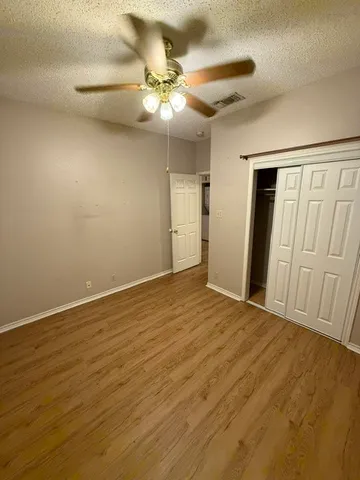 a view of an empty room with a chandelier fan