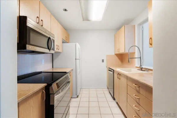 a kitchen with a sink and a stove top oven