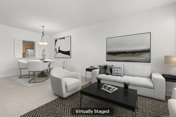 a living room with furniture a rug and wall painting