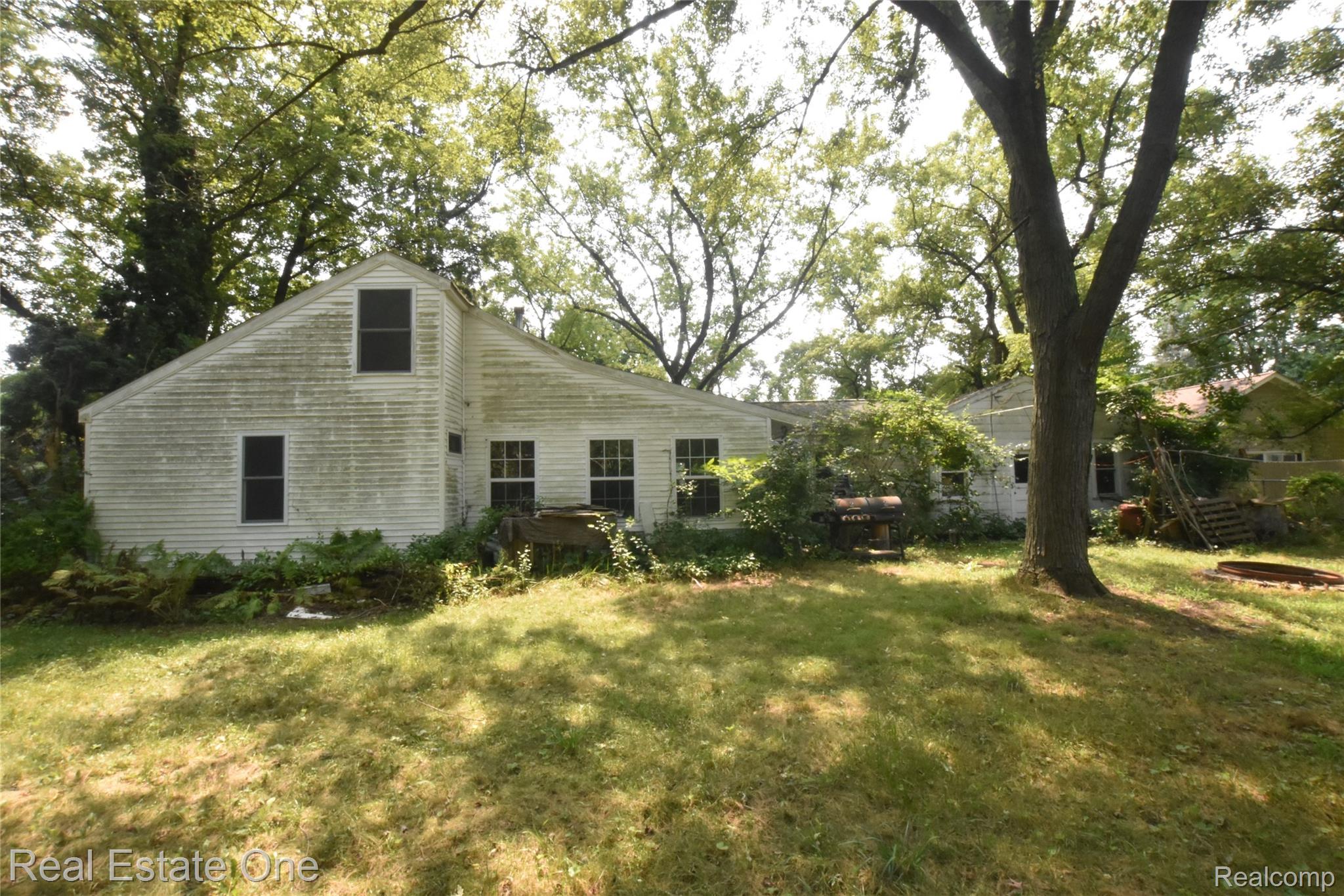 3482 West Maple Road Wixom, MI 48393 - Photo 5 of 17 Rear elevation featuring white siding and multiple windows