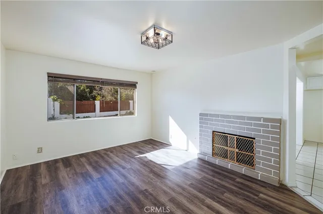 a view of empty room with wooden floor and fireplace
