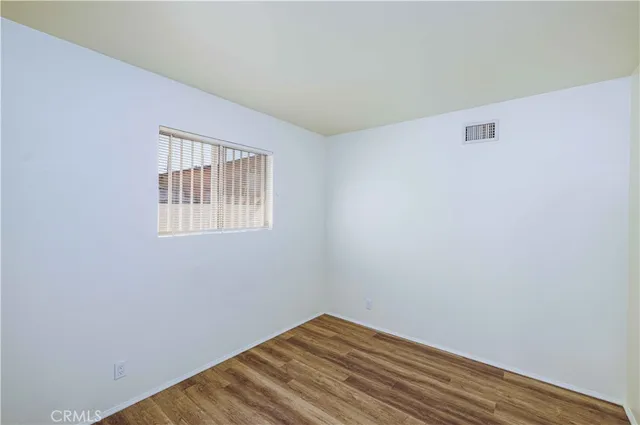 a view of a room with wooden floor and white walls