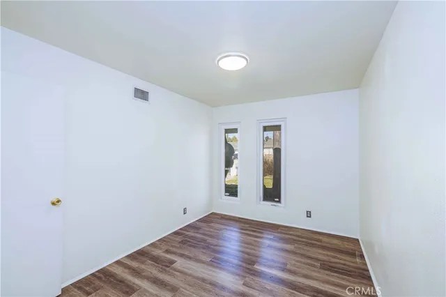 a view of a room with wooden floor and white walls