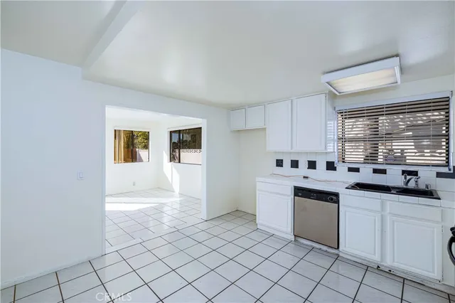 a kitchen with white cabinets and white appliances
