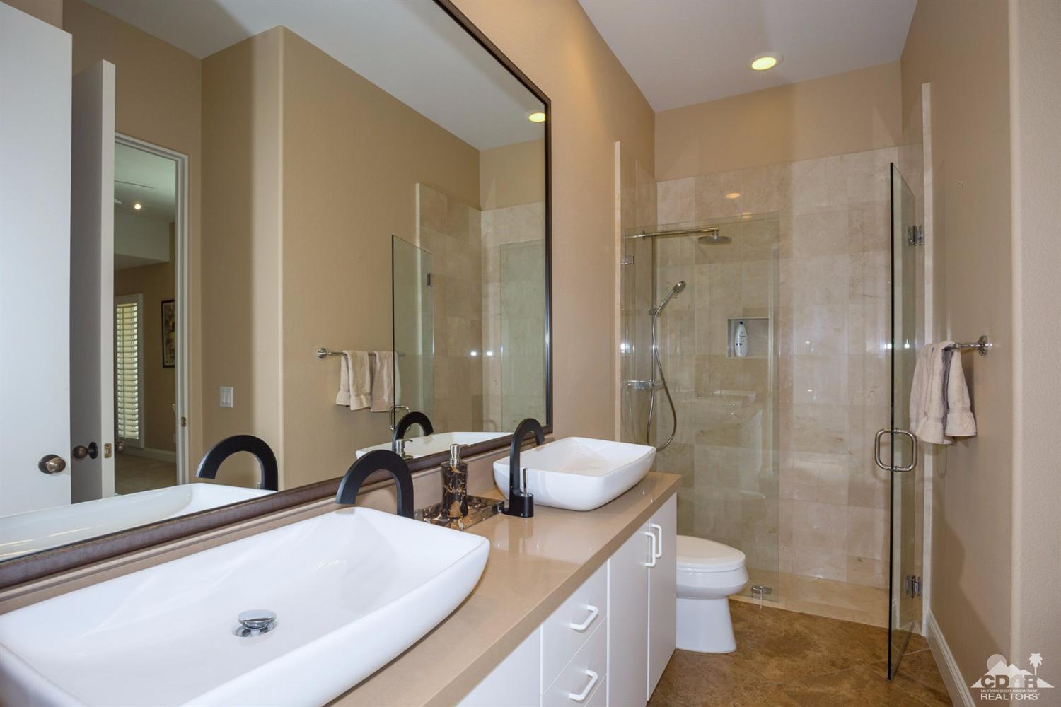 80352 Riviera La Quinta, CA 92253 - Photo 20 of 31 a bathroom with a double vanity sink toilet and shower