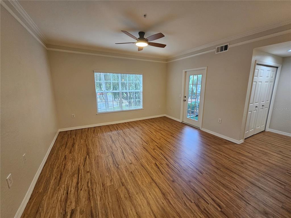5174 Northridge Road, Unit 209 Sarasota, FL 34238 - Photo 5 of 25 an empty room with wooden floor and windows