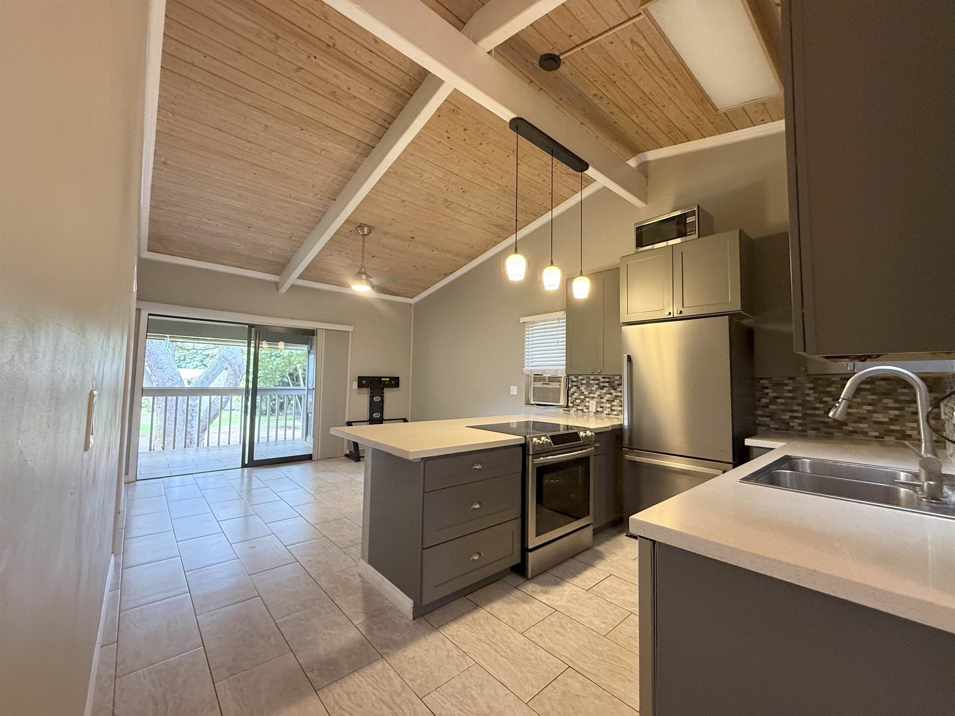 4435 Lower Honoapiilani Road, Unit 235 Lahaina, HI 96761 - Photo 16 of 21 a kitchen with a stove a sink and a refrigerator