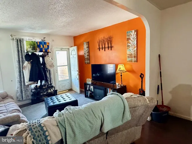 a living room with furniture a flat screen tv and a window