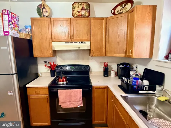 a kitchen with stainless steel appliances a stove a refrigerator a sink and cabinets