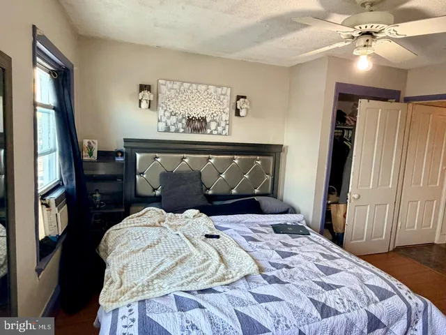 a bedroom with a bed and a mirror on the dresser