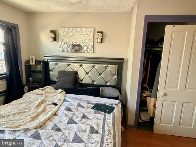 a bed sitting in a bedroom next to a window with wooden floor
