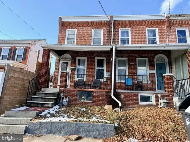 front view of a brick house with a small yard