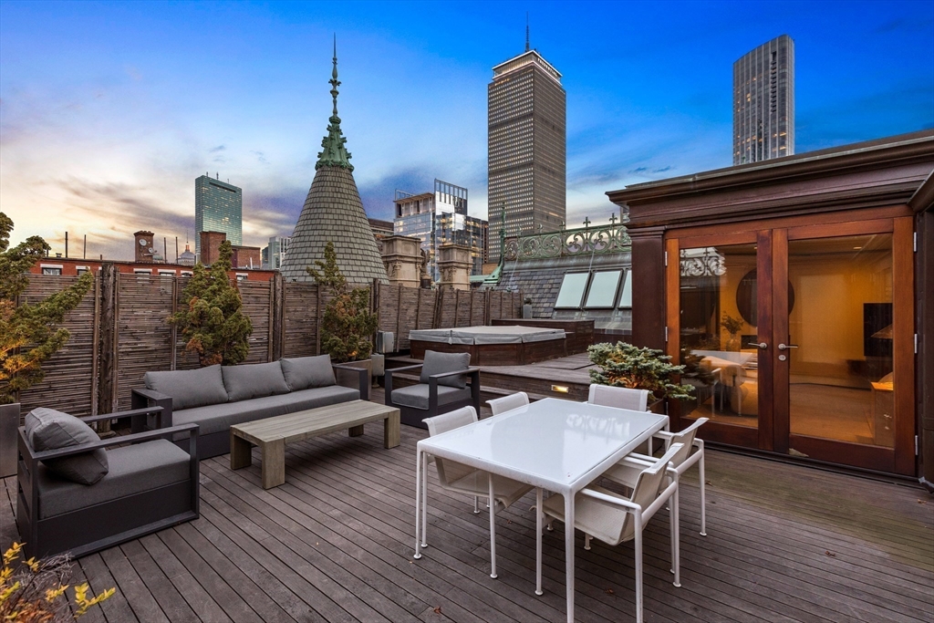 314 Commonwealth Avenue, Unit PH Boston, MA 02115 - Photo 37 of 41 a view of a patio with couches dining table and chairs with wooden floor