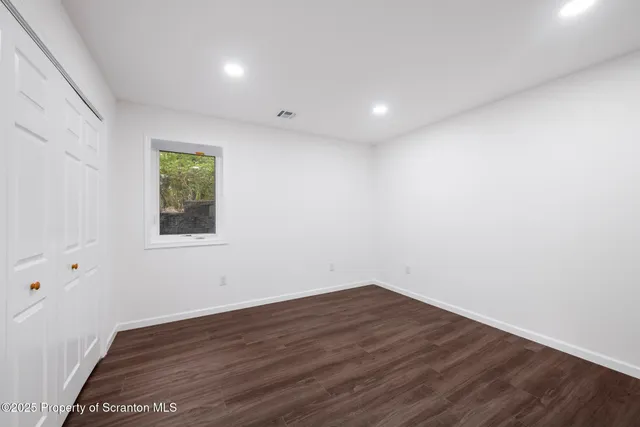 a view of a room with wooden floor and window