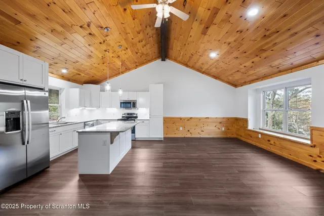 a kitchen with stainless steel appliances granite countertop a sink a stove top oven a counter space and cabinets