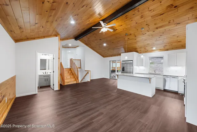 a view of a kitchen with wooden floor and electronic appliances
