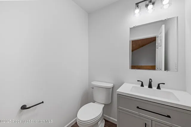 a bathroom with a toilet sink vanity and mirror