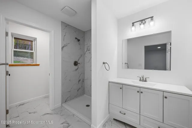 a bathroom with a shower sink and mirror