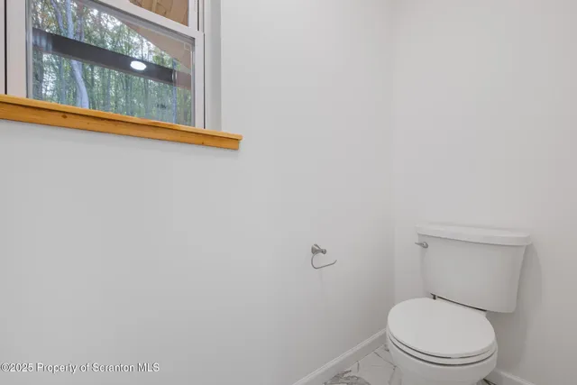 a white toilet sitting next to a shower