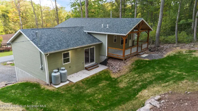 a view of a house with a yard and large tree