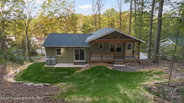 a front view of a house with a yard and trees
