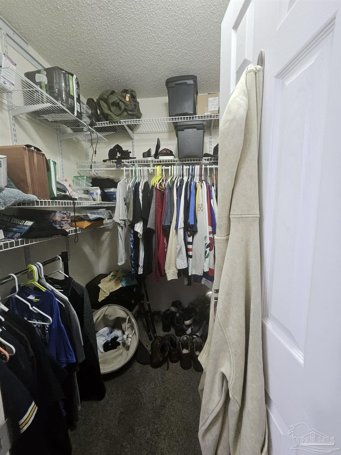 3661 Burton Circle Navarre, FL 32566 - Photo 12 of 17 a view of walk in closet with clothes and shoes