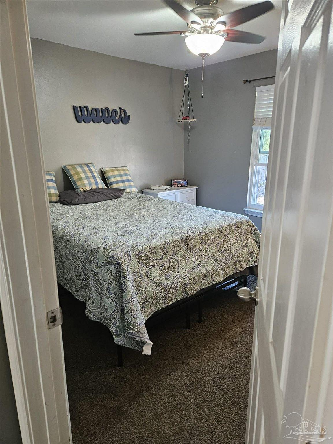 3661 Burton Circle Navarre, FL 32566 - Photo 14 of 17 a bedroom with a bed and a chandelier