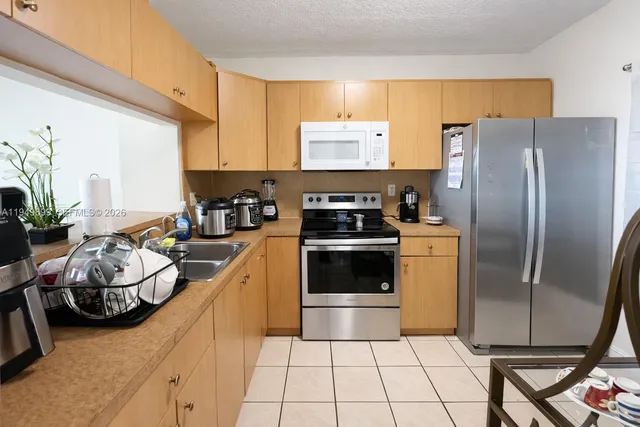 a kitchen with stainless steel appliances a refrigerator sink and cabinets