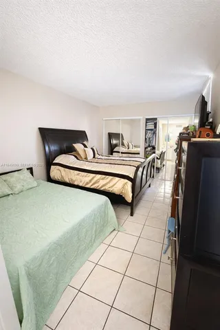 a bedroom with two beds and a view of kitchen