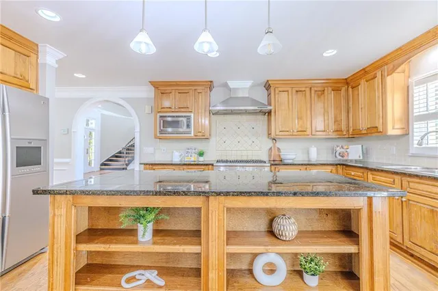 a dining room with wooden floor a chandelier a glass table and chairs