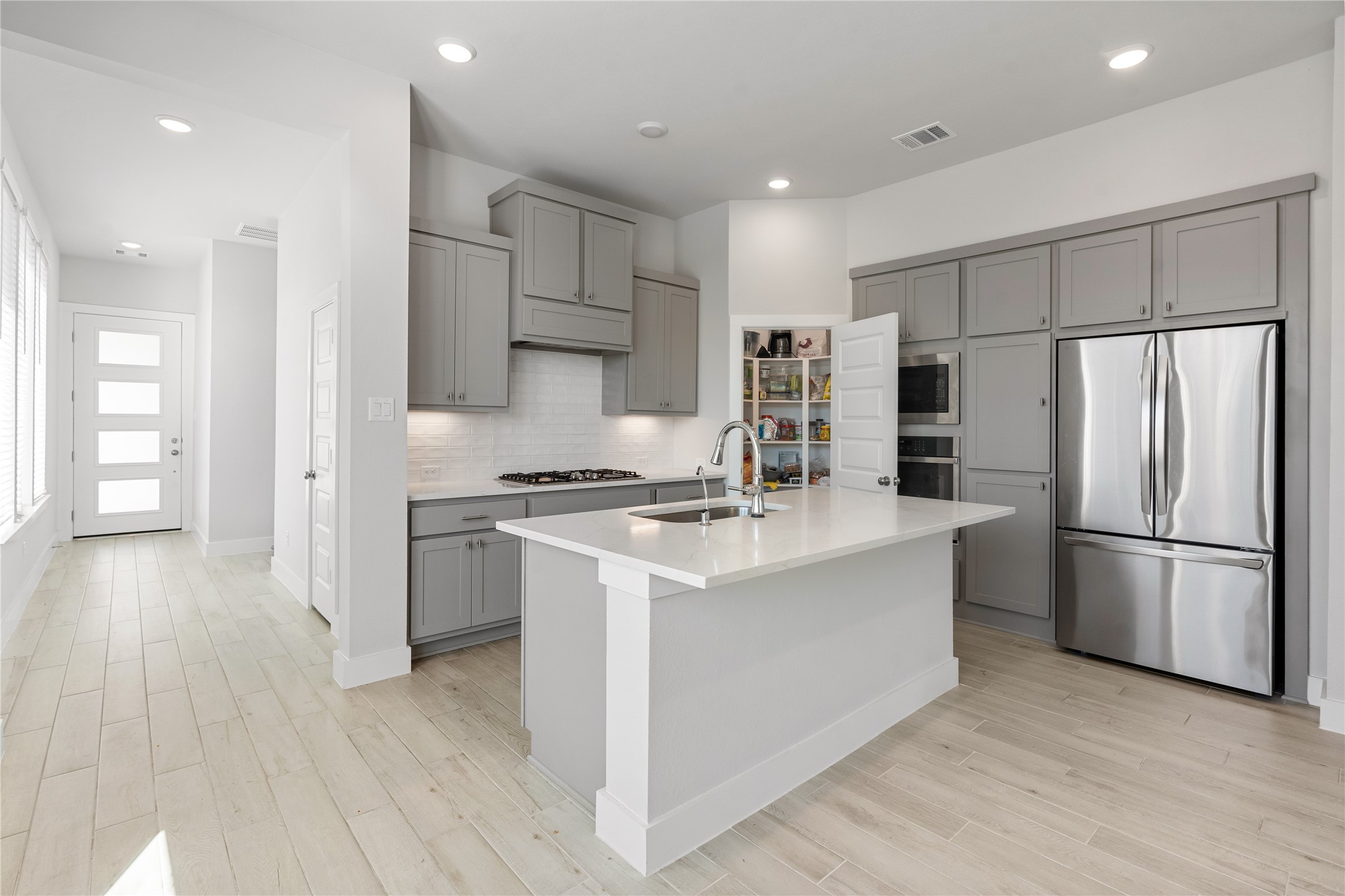 17623 Azalea Clf Court Richmond, TX 77407 - Photo 13 of 33 a kitchen with stainless steel appliances a refrigerator stove microwave and cabinets