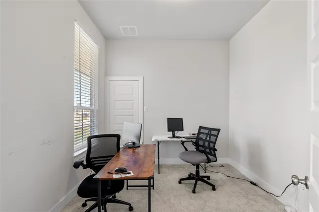 a view of a workspace with furniture and a window