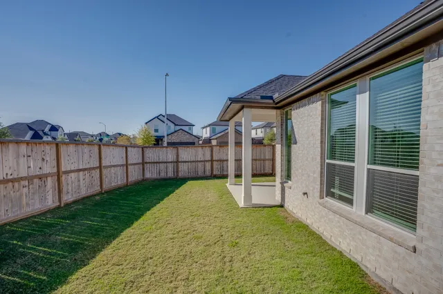 a view of a backyard with wooden fence