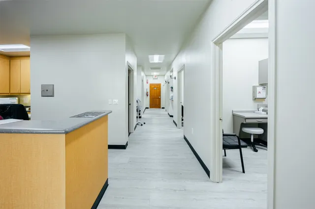a view of a hallway with wooden floor and furniture