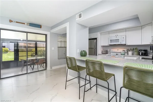 a kitchen with a table chairs and a counter top space