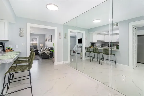 a living room with furniture a large window and stainless steel appliances