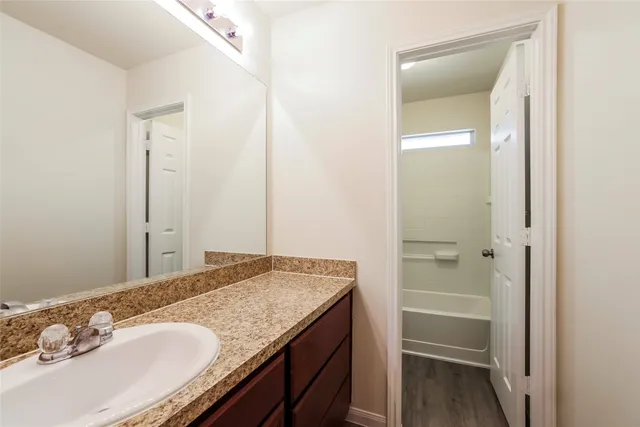 a bathroom with a granite countertop sink and a mirror