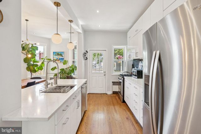 a view of a dining room and livingroom with furniture wooden floor a rug and a chandelier